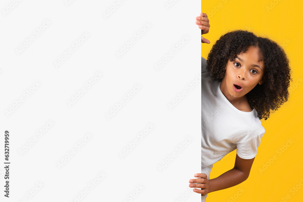 Shocked positive teenage black pupil girl in white t-shirt near banner with copy space Shocked positive teenage black pupil girl in white t-shirt near banner with copy space