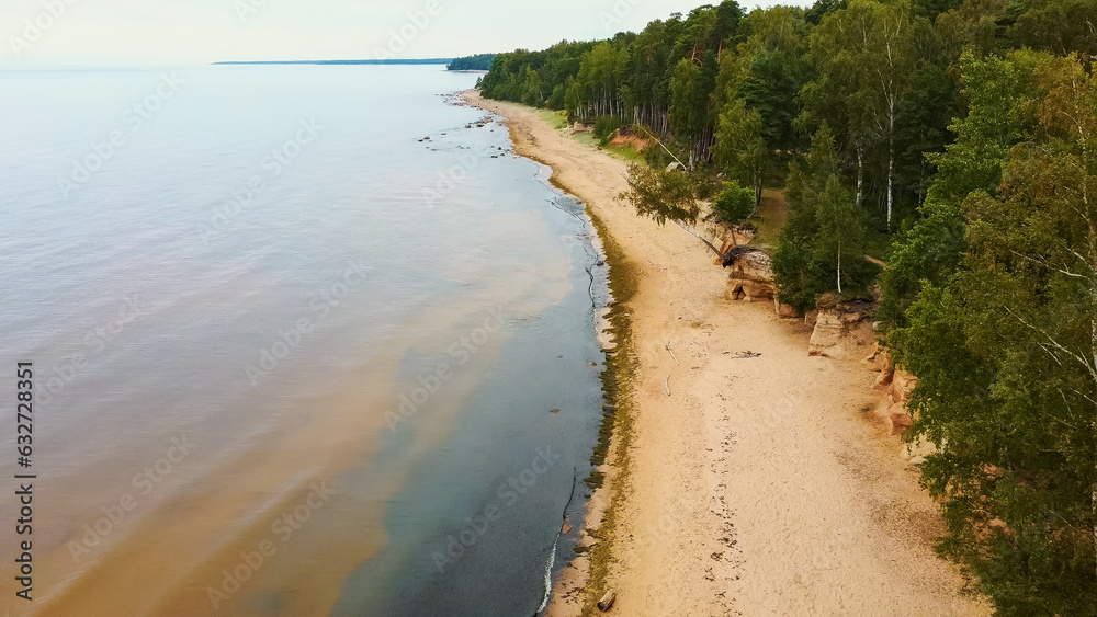 Veczemju Cliffs Red Rocks, Latvia. Red Sandstone Cliff by the Baltic Sea Coast of Vidzeme With Waves, Rocks and Cloudy Rainy Summer Day. Aerial View Veczemju Cliffs Red Rocks, Latvia. Red Sandstone Cliff by the Baltic Sea Coast of Vidzeme With Waves, Rocks and Cloudy Rainy Summer Day. Aerial View