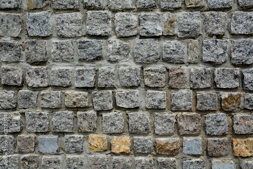 texture of a stone wall made of granite bricks close-up