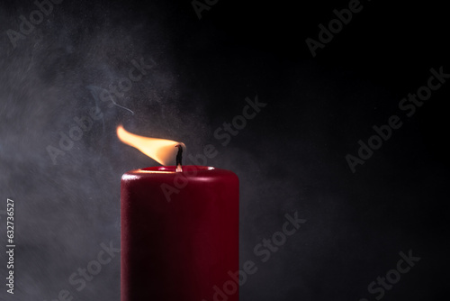 czerwona świeca na ciemnym tle jako symbol pamięci i przemijania