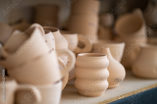 Pottery shelf in studio, creative store clay products, collection and display in workshop. © zinkevych
