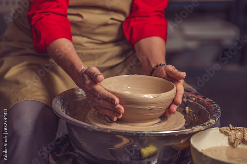 Woman potter creating beautiful plate with clay, making works of art with his hands.