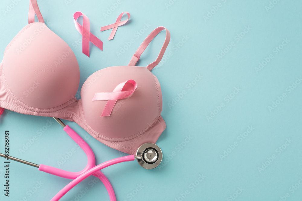 Remembering breast cancer awareness: Top view of pink ribbons, stethoscope, and bra, adorning the pastel blue background with text or advertising space Remembering breast cancer awareness: Top view of pink ribbons, stethoscope, and bra, adorning the pastel blue background with text or advertising space