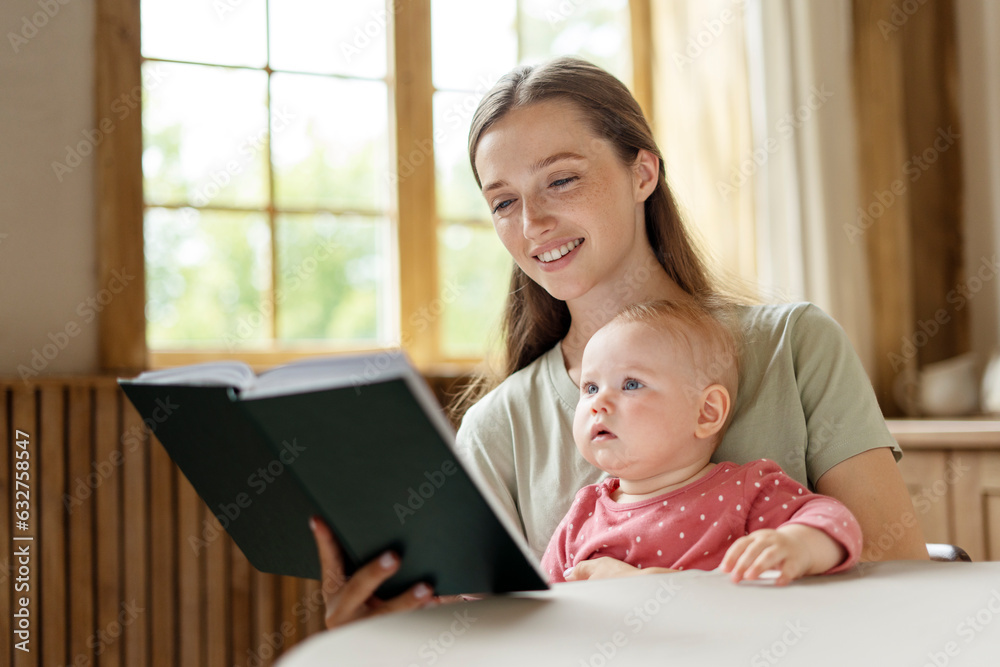 Young beautiful mother reading book for her little cute baby at home Young beautiful mother reading book for her little cute baby at home