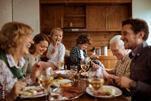 Fotografi Multigenerational family having lunch together in the dining room at home