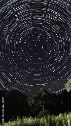 A view of the stars of the Milky Way with a mountain top in the foreground. Night sky nature summer landscape. Perseid Meteor Shower observation. Vertical video for social media. photo