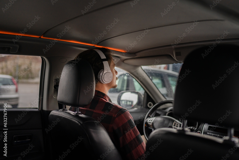 one man with headphones sit in the car listen guided meditation