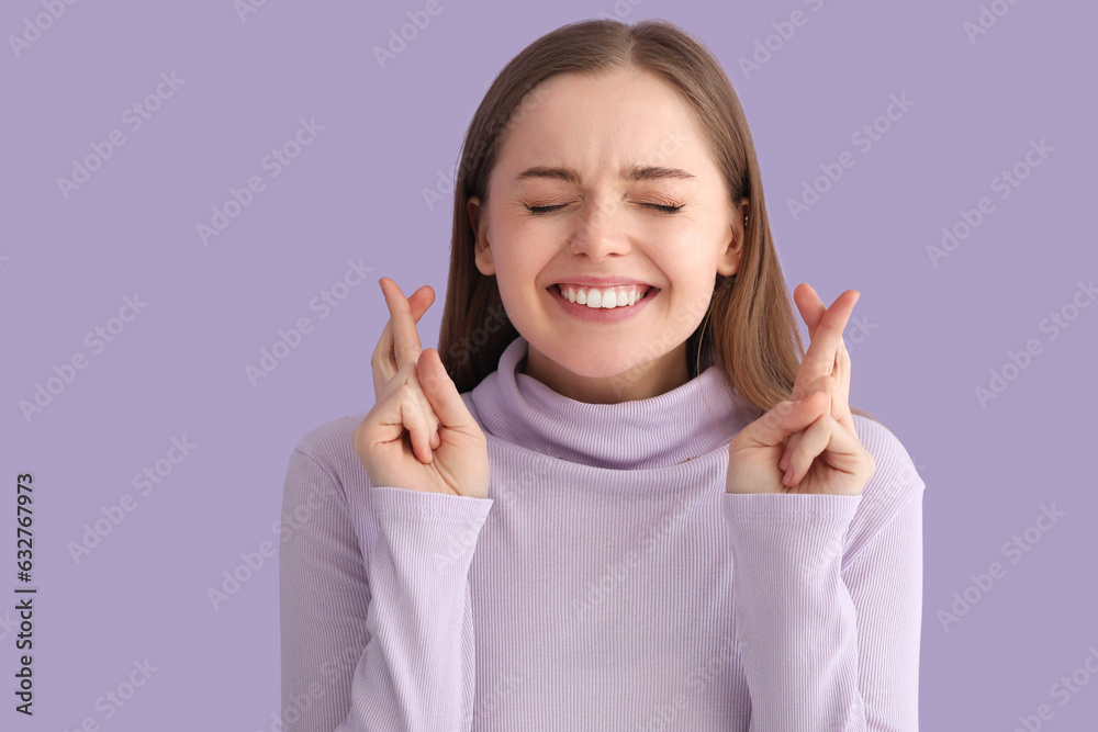 Young woman in sweater crossing fingers on lilac background, closeup Young woman in sweater crossing fingers on lilac background, closeup