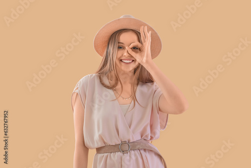 Young woman in hat showing ...