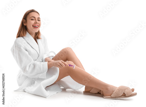 Young woman shaving legs wi...