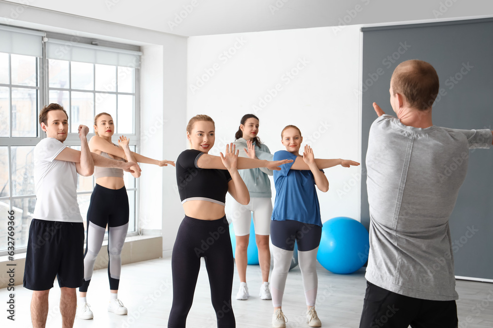 Group of sporty young people training in gym Group of sporty young people training in gym