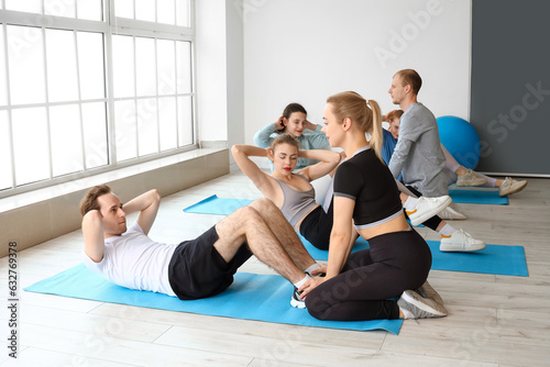 Group of sporty young people training in gym
