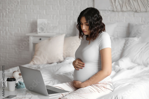 Young pregnant woman workin...