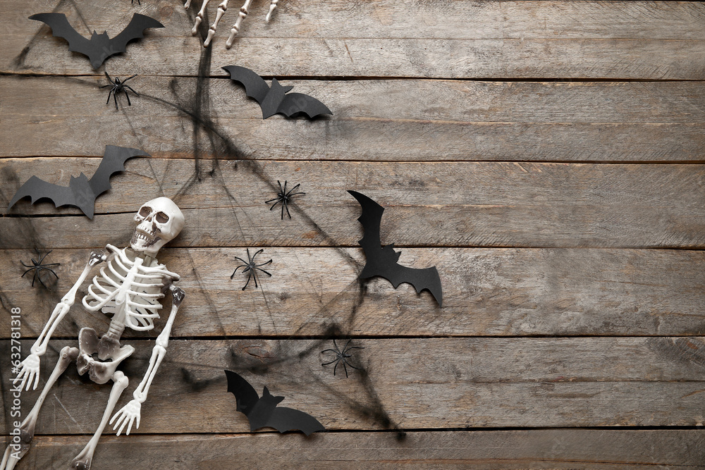 Composition with skeleton and Halloween decor on wooden background
