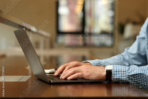 Man working on laptop at table in cafe, closeup © New Africa