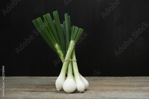 Bunch of fresh green spring onions on wooden table