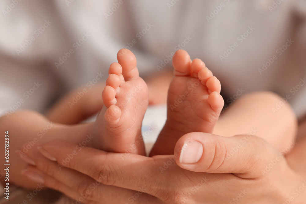 Mother holding her newborn baby, closeup view on feet. Lovely family Mother holding her newborn baby, closeup view on feet. Lovely family