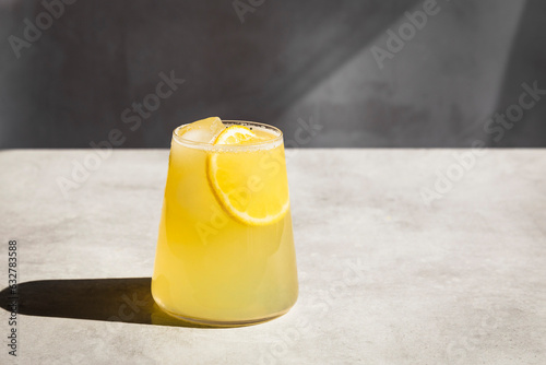 Homemade lemonade with ice and lemon slices in a glass.