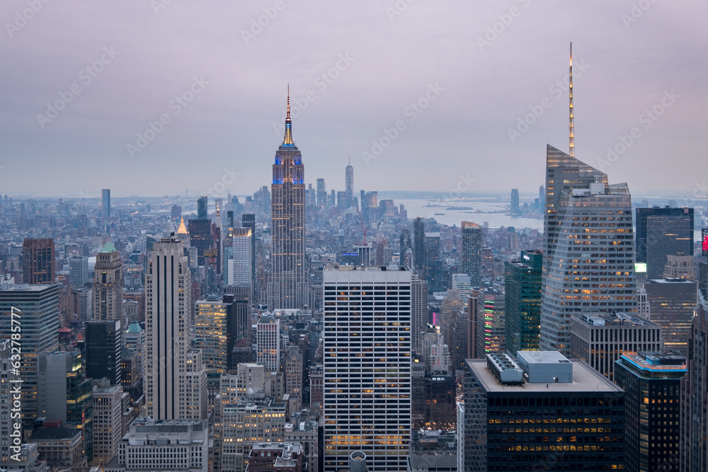 Panoramic view of the Manhattan skyline at sunset, with the Empire State Building in the foreground