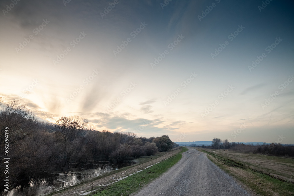 Panorama of a dyke over the danube river at dusk in Ivanovacka ada, an island in ivanovo, serbia, in vojvodina, in eastern europe, during a cold winter.
