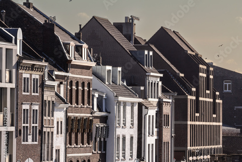 Typical facades of dutch architecture in the city center of Maastricht, Netherlands, with residential buildings, facades of red brick and flats.