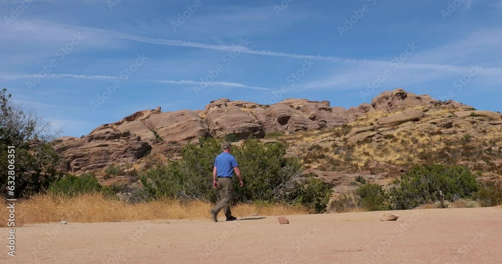 Caucasian man hikes in the desert southwest, California near rock formations. Caucasian man hikes in the desert southwest, California near rock formations.