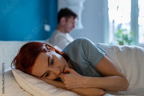 Fotografia Upset wife lies with her back to husband