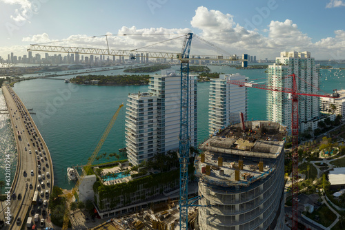 Aerial view of new developing residense in american urban area. Tower cranes at industrial construction site in Miami, Florida. Concept of housing growth in the USA photo
