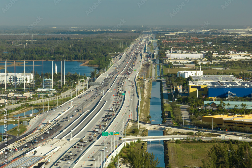 View from above of american wide freeway in Miami, Florida with dense traffic of driving cars during rush hour. USA transportation infrastructure concept