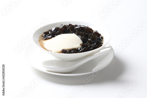 black herbal grass jelly with white soya milk pudding and sweet syrup sauce in white bowl yuan yang asian traditional dessert halal vegan food menu for Hong Kong cafe photo