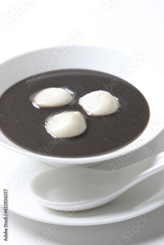 chef cook thick black sesame sweet soup with peanut glutinous rice ball 3pcs tang yuan in white bowl hot sweet asian festive traditional dessert halal food vegan menu for Hong Kong cafe photo