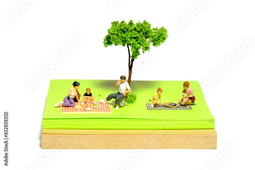 Creative miniature people toy figure photography. Sticky notes installation. Family picnic time at public garden, park on summer holiday. Isolated on white background