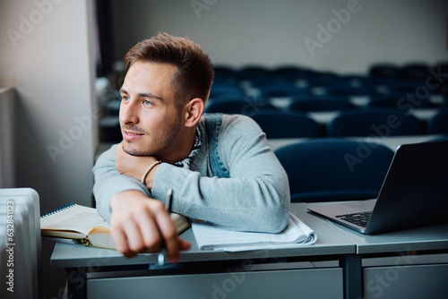 Pensive student day dreaming while studying at university classroom.