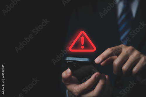 Businessman using laptop showing warning triangle and exclamation sign icon Warning of dangerous problems server error	
