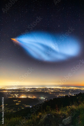 Pink and bluish glow from a Falcon 9 rocket launch appears over San Diego County
