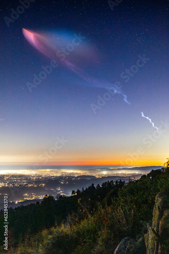 Pink and bluish glow from a Falcon 9 rocket launch appears over San Diego County