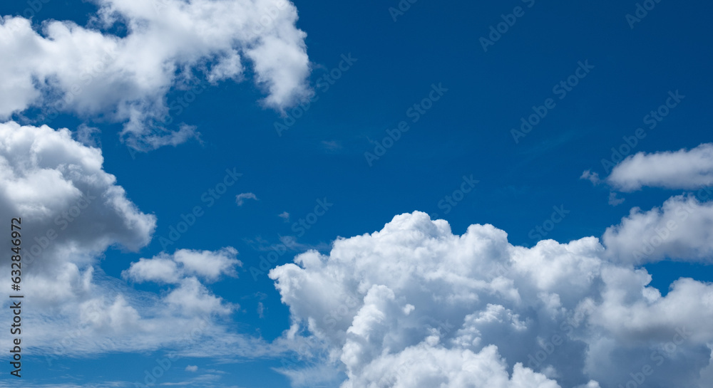 Obraz premium 夏の晴天、青空に流れる積乱雲ふわふわの入道雲の背景壁紙 夏・夏休み・行楽・バカンス・アウトドア・キャンプ・天気・台風一過