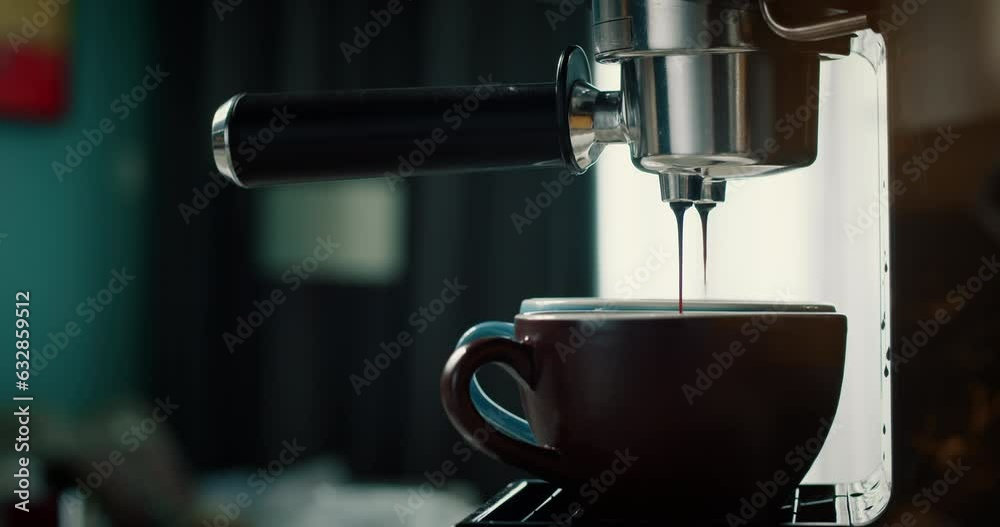 Pouring coffee stream from machine in red and broun cup. Home making hot Espresso. Using filter holder. Flowing fresh ground coffee. Drinking roasted black coffee in the morning. 4K Pouring coffee stream from machine in red and broun cup. Home making hot Espresso. Using filter holder. Flowing fresh ground coffee. Drinking roasted black coffee in the morning. 4K