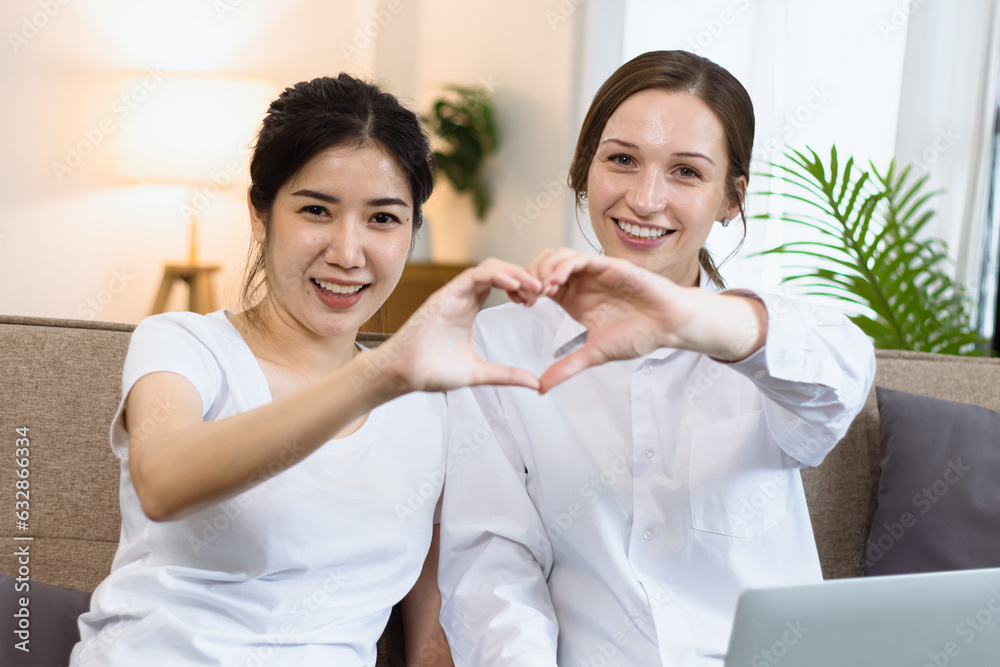 Two roommates woman sitting on a sofa in the living room at home, Friendship and sisterhood concept. Two roommates woman sitting on a sofa in the living room at home, Friendship and sisterhood concept.