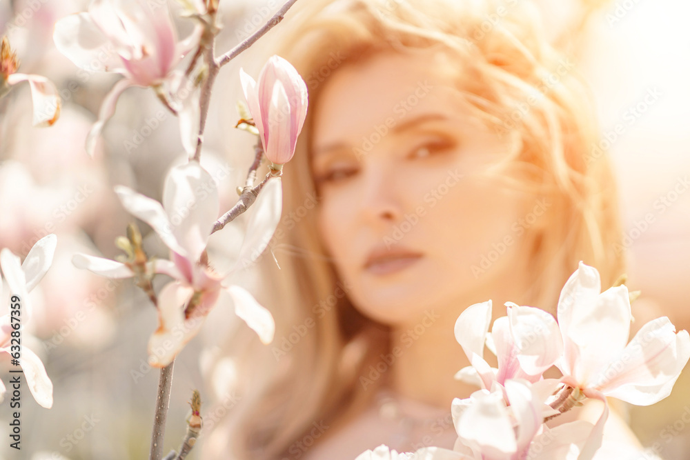 Magnolia woman portrait. Happy middle aged woman enjoying the smell in a blooming spring garden. Beautiful magnolia bushes, large flowers. Magnolia woman portrait. Happy middle aged woman enjoying the smell in a blooming spring garden. Beautiful magnolia bushes, large flowers.
