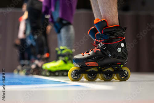 Close-up of roller skates of people training figure skating in a sports hall. Photo taken with artificial lighting of the sports hall.