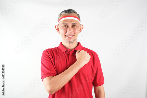 Portrait of Asian Man holding red and white Indonesia flag attribute. Independence day concept. 