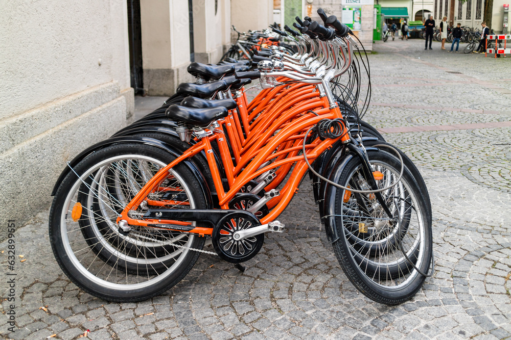 Row of identical orange bicycles