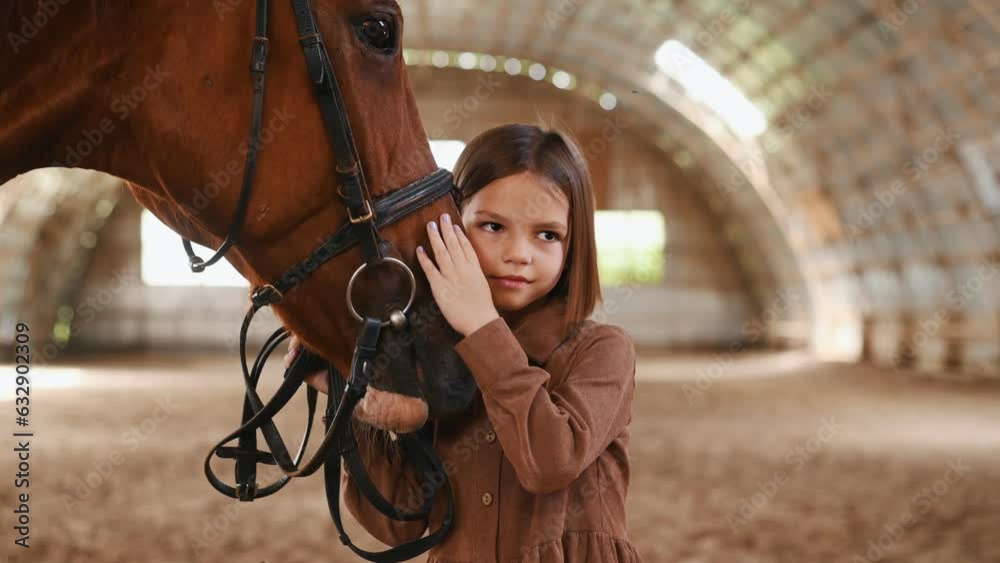 Cute little girl is with horse indoors. Cute little girl is with horse indoors.