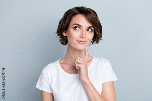 Photo of dreamy charming woman dressed white t-shirt finger chin looking empty space isolated grey color background
