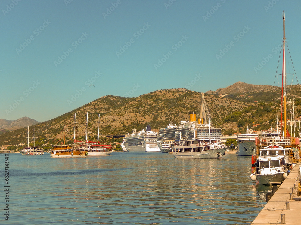 Dubrovnik Cruise port with ships and tourism boats in the harbor water with hills and clear sky in Croatia Dubrovnik Cruise port with ships and tourism boats in the harbor water with hills and clear sky in Croatia