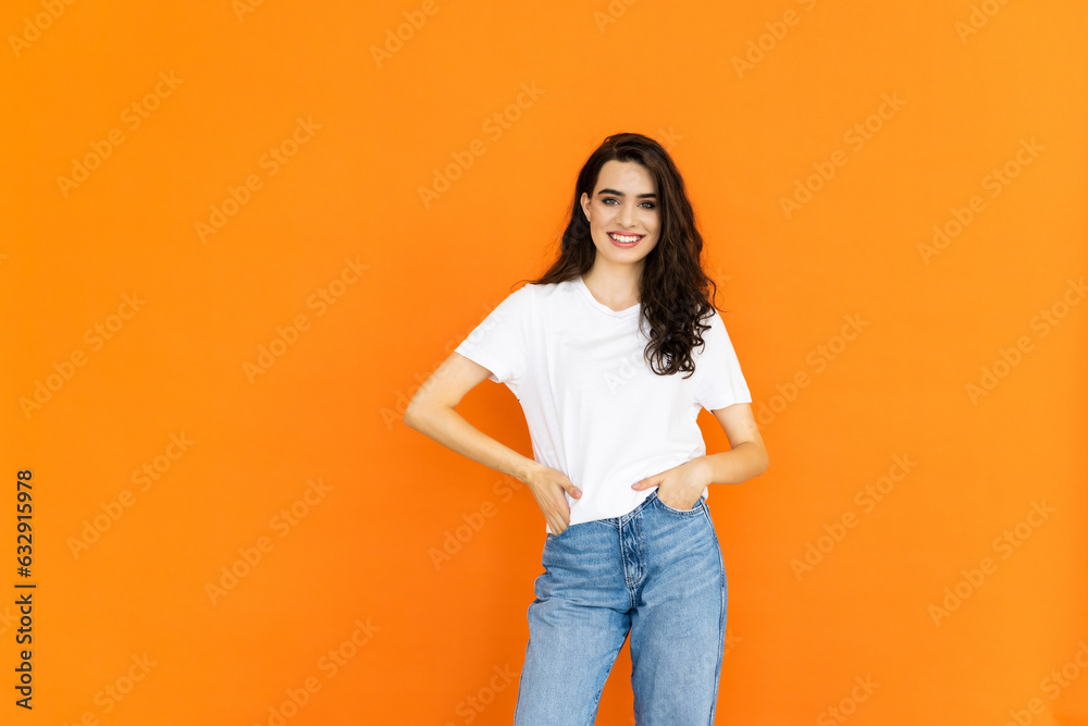 Photo portrait of female smiling with folded hands isolated on bright orange color background Photo portrait of female smiling with folded hands isolated on bright orange color background