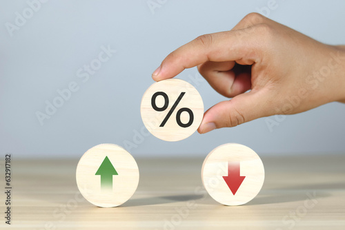 Financial interest rate holding wooden block with percentage sign and up arrow, financial growth, interest rate increase, inflation rate, selling price and tax hike concept and rate simulation 