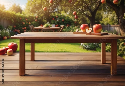 A wooden table with apple on the right and copy space on the left, garden on the background