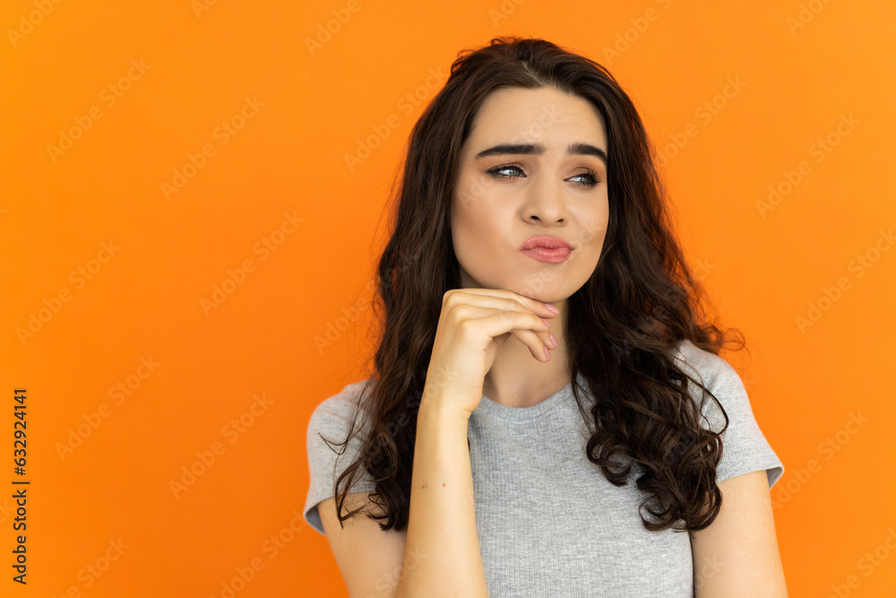 Pensive woman. Obesity problem. Body positive. Hard decision. Thoughtful confused overweight girl on orange background. Pensive woman. Obesity problem. Body positive. Hard decision. Thoughtful confused overweight girl on orange background.